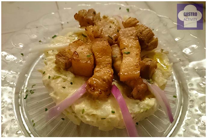 Ensaladilla rusa con torreznos de panceta ibérica en restaurante El Buey Madrid Ensaladilla rusa con torreznos de panceta ibérica